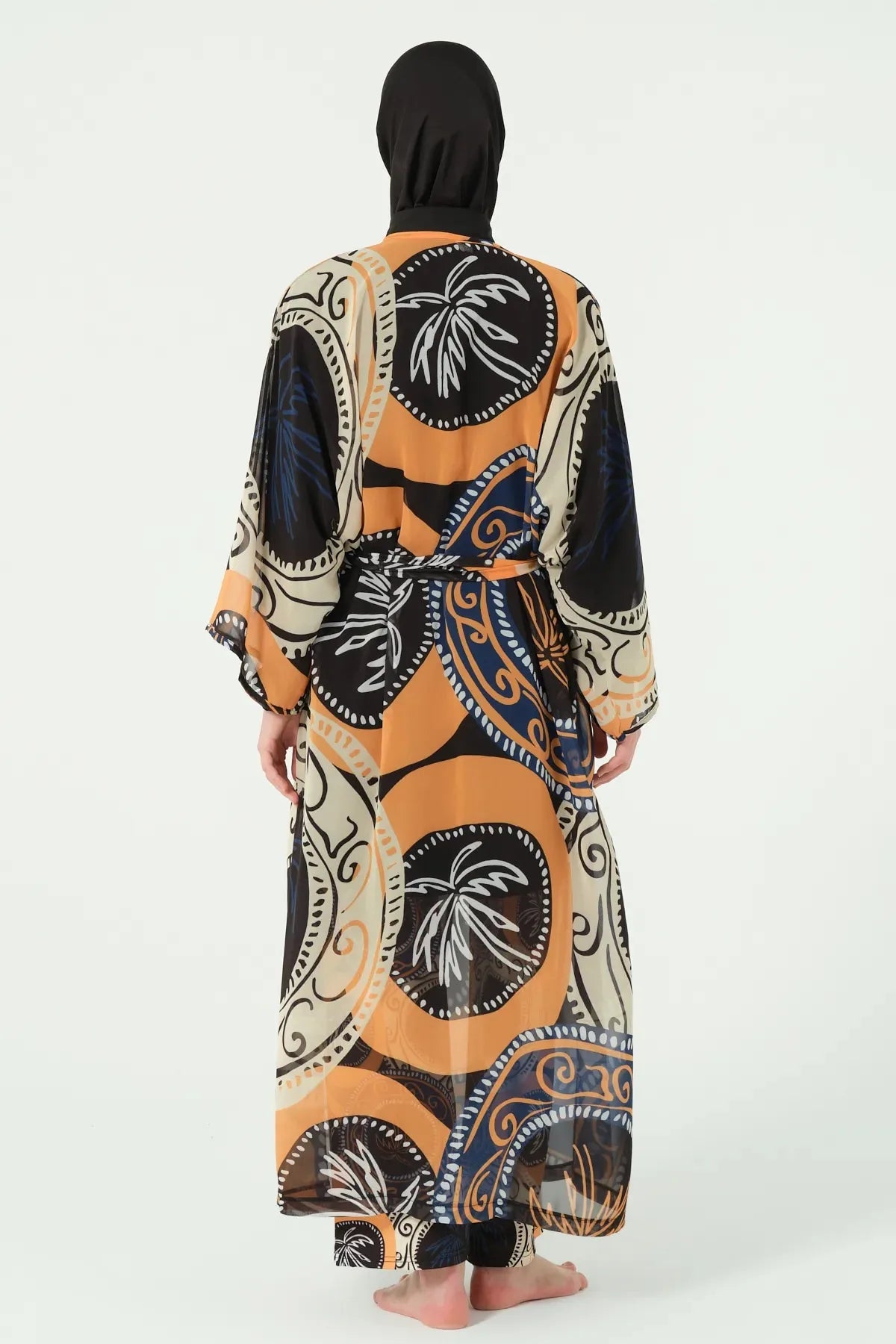 Model wearing abstract print sheer kimono with tie belt, back view.