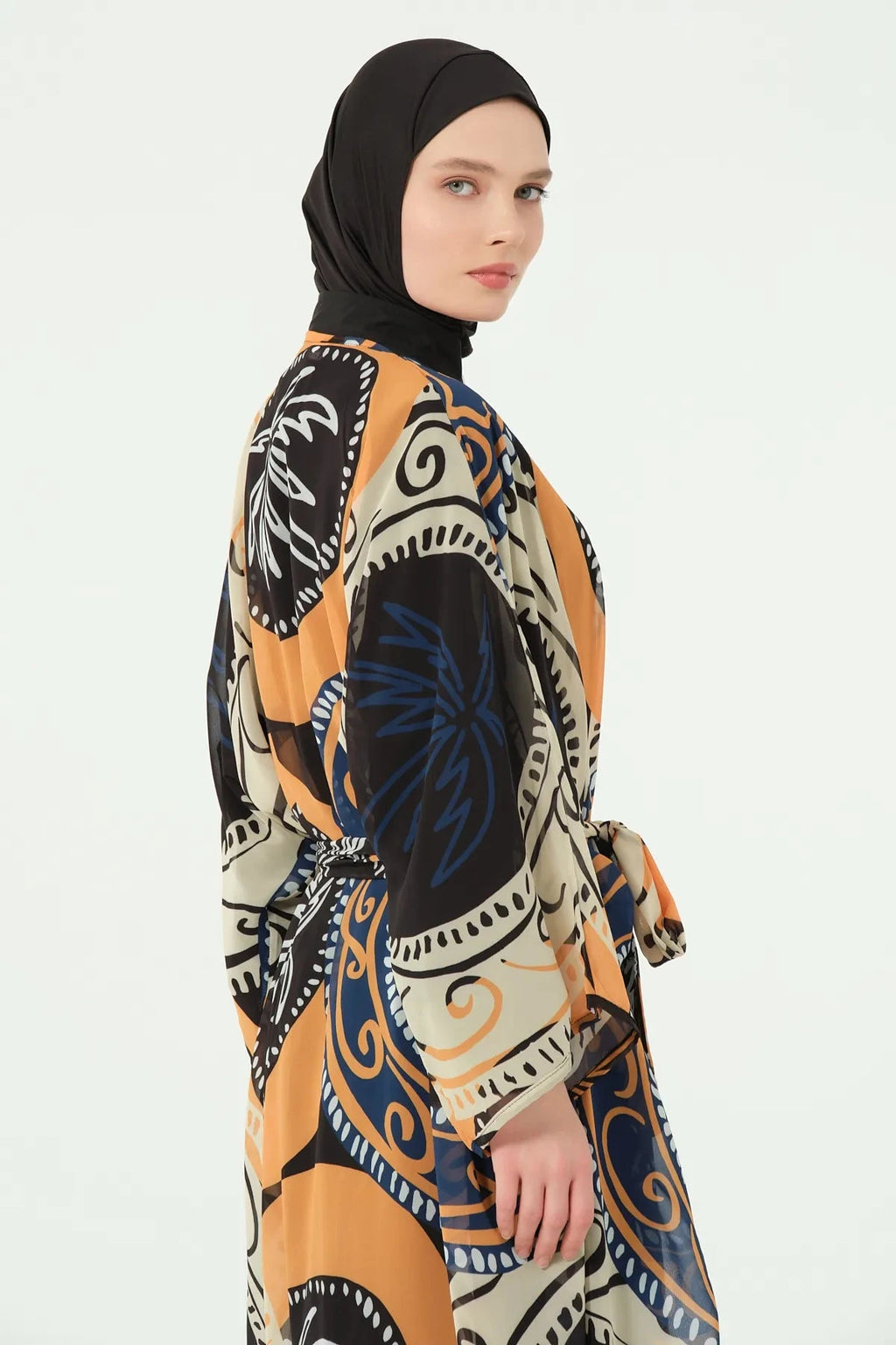 Close-up of model wearing abstract print sheer kimono, side view.
