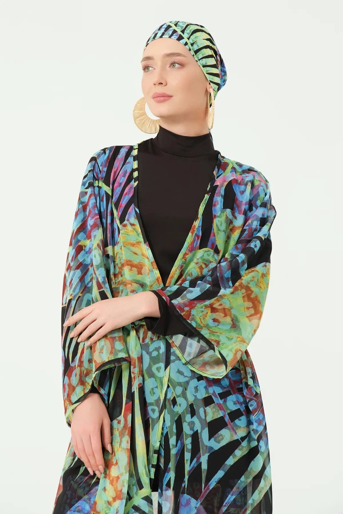 Close-up of model wearing multi-color sheer kimono and black high-neck swimsuit.