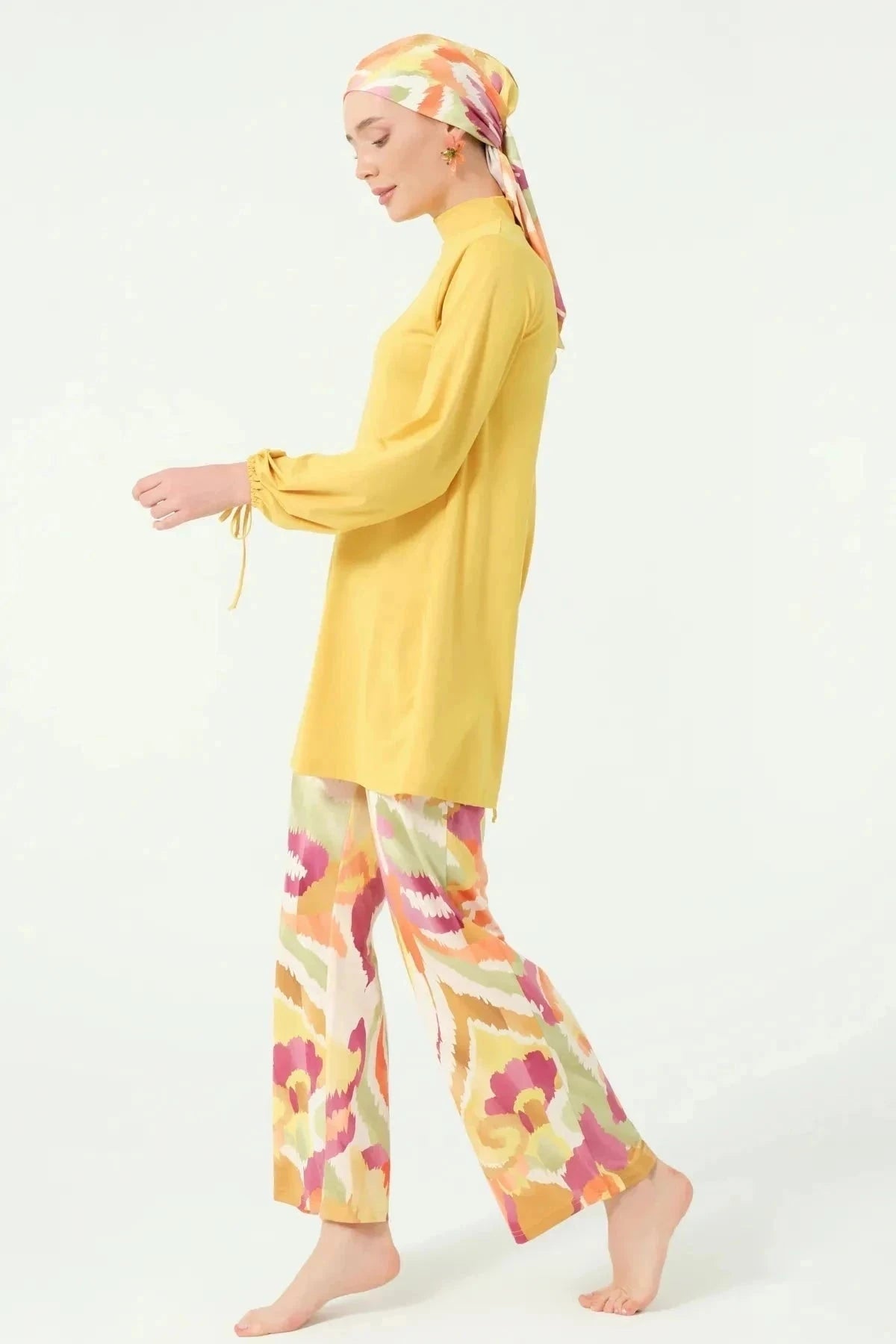 Woman in golden yellow modest swimwear set walking side view