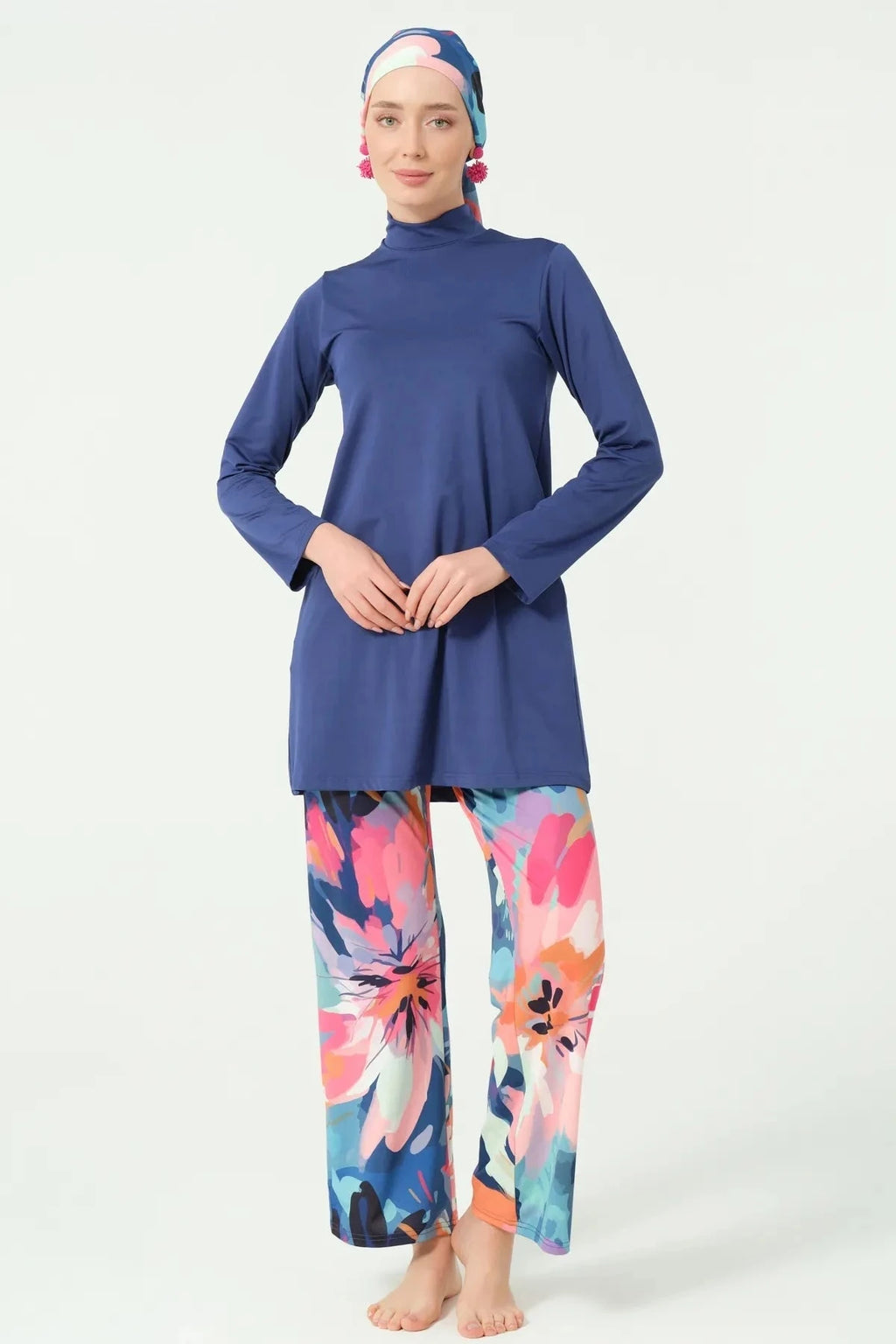 Model in indigo long-sleeve tunic and floral swim pants, front view.