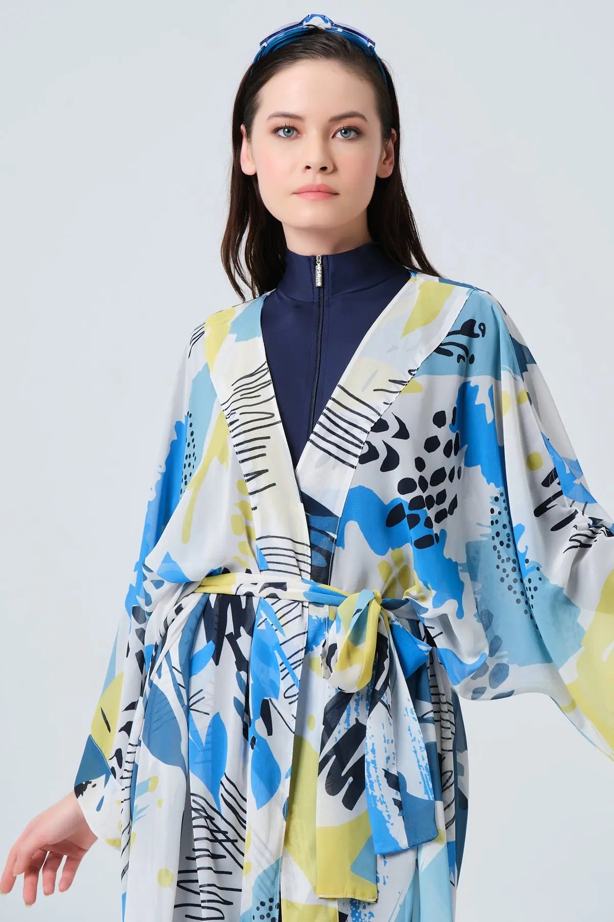 Close-up of blue and yellow printed kimono swimwear with tied belt.