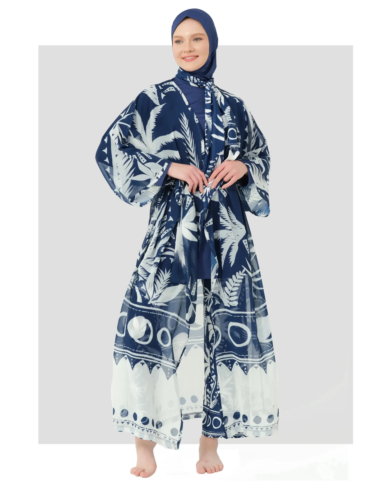 Woman in navy and white tropical print kimono with belt, front view.