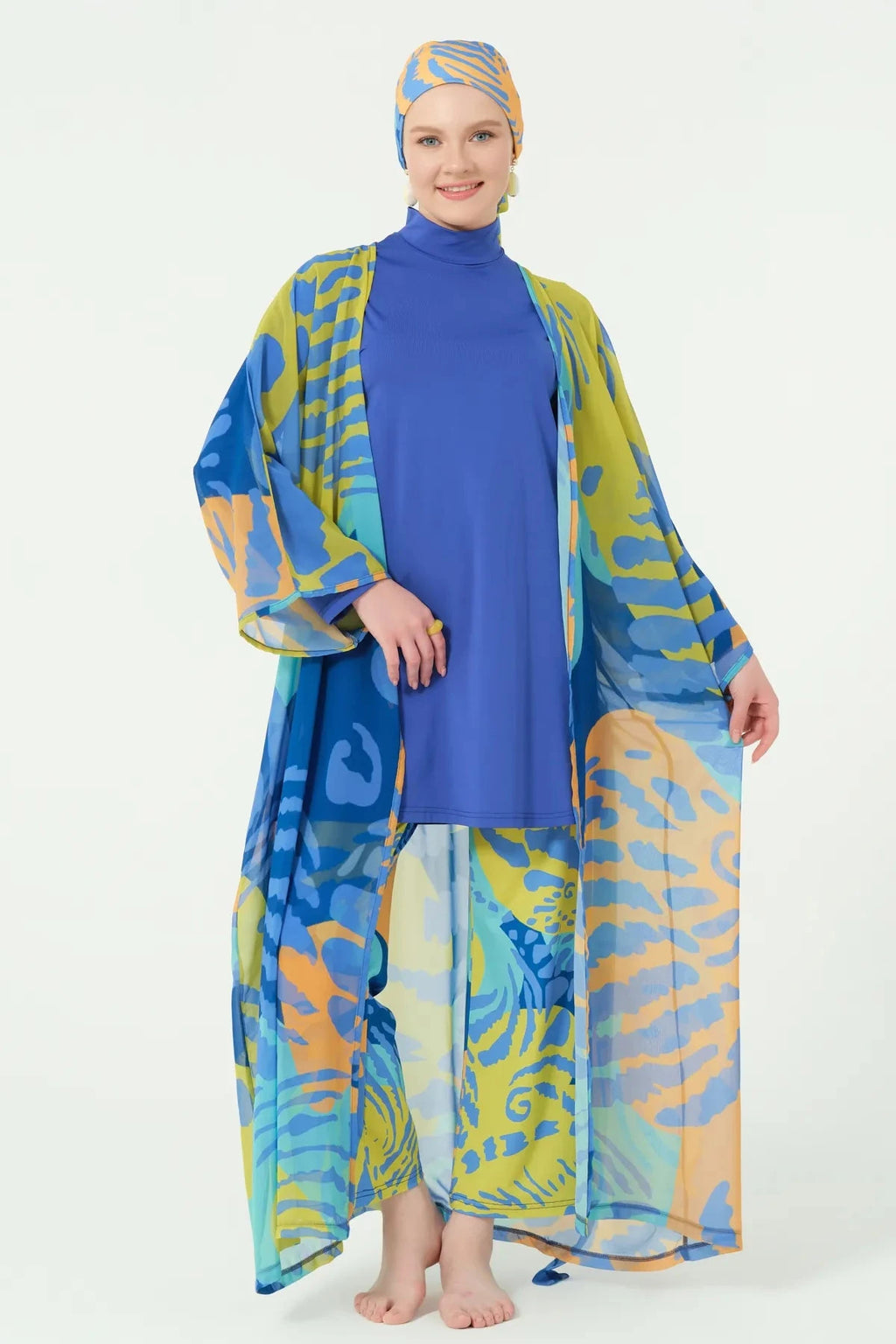 Woman in tropical print kimono open, showing blue full coverage swimsuit, front view.