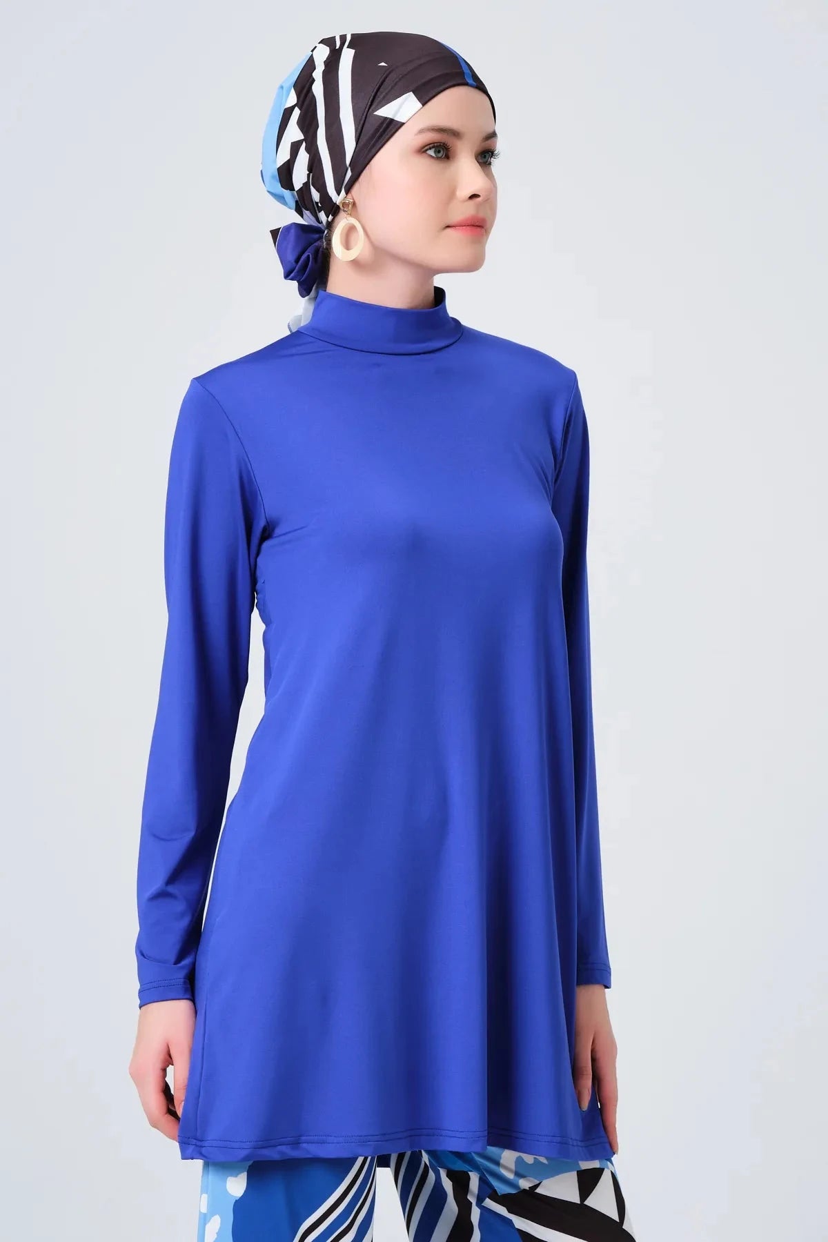 Close-up of sapphire blue modest burkini tunic and patterned headscarf.
