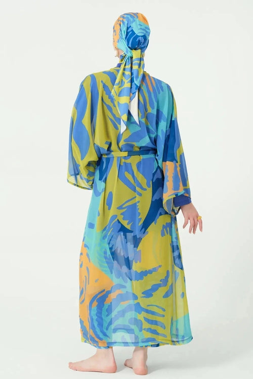 Model in abstract print kimono modest swimwear set back view.