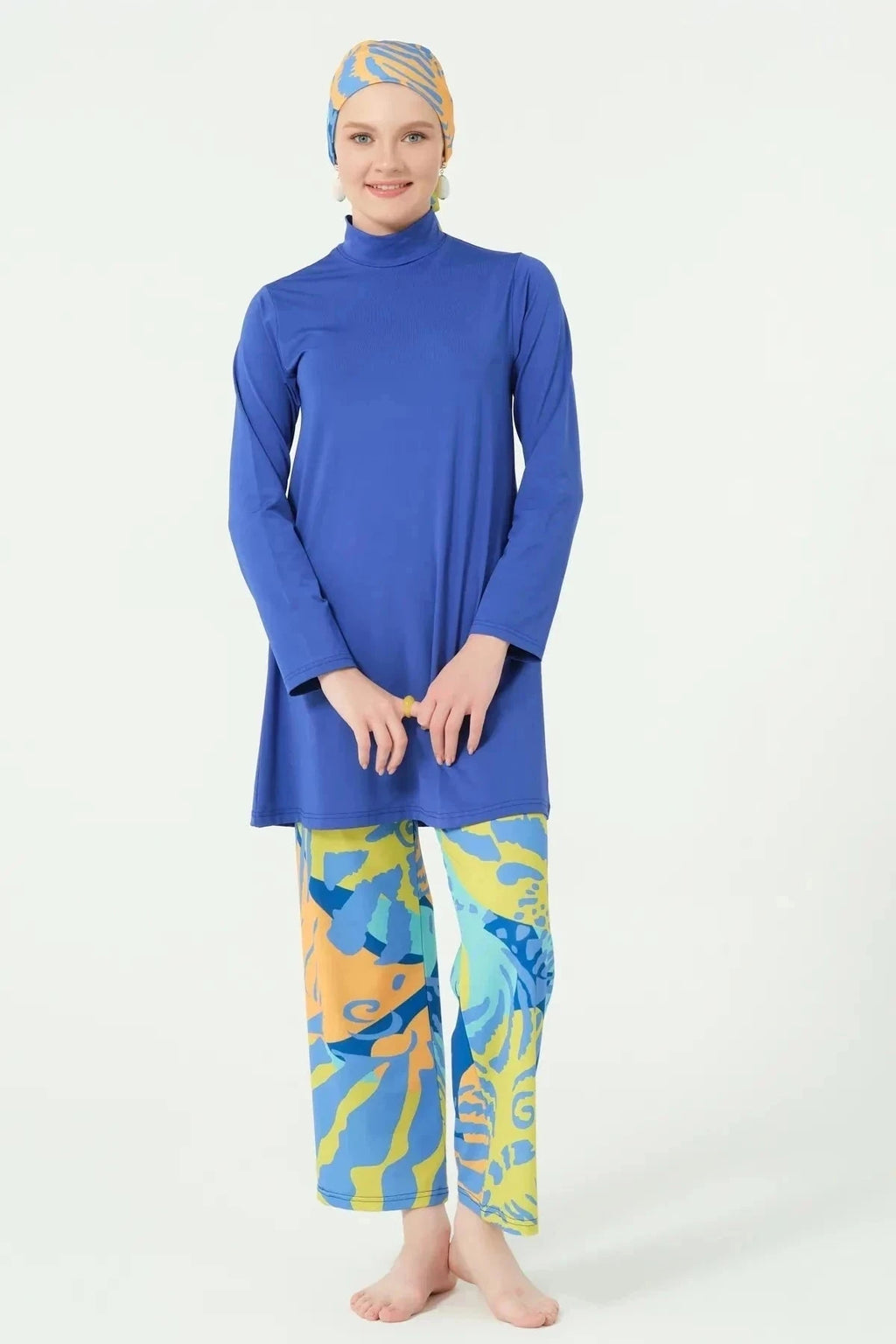 Model in blue modest swim top and abstract print pants front.