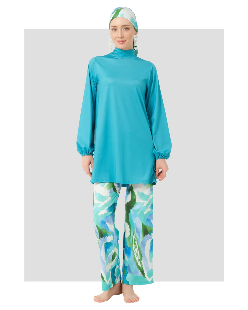 Woman in turquoise modest swimwear set with printed pants, front view.
