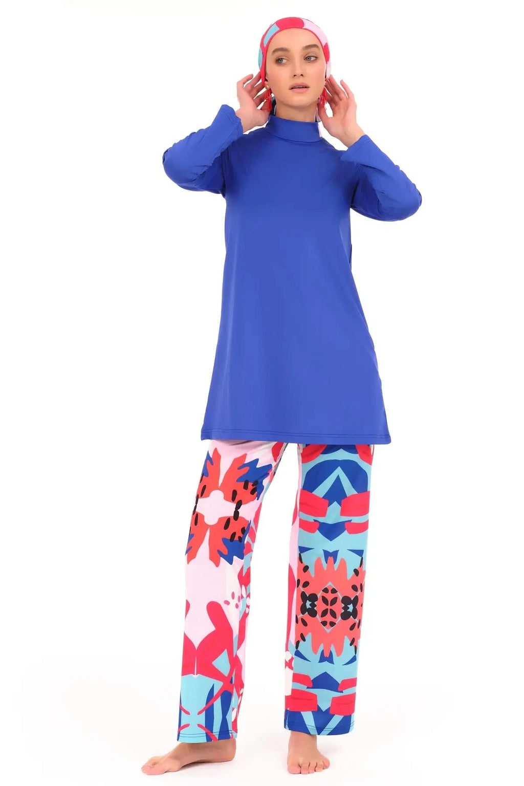 Royal blue modest swimwear set with patterned pants, hands near head.