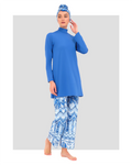 Model in cobalt blue modest swimwear set, front angle, hand near face.