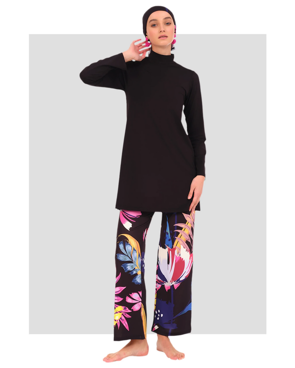 Model in black tunic, floral pants, and headscarf, front view.