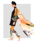 Model wearing orange floral sheer kimono over black modest swimwear.