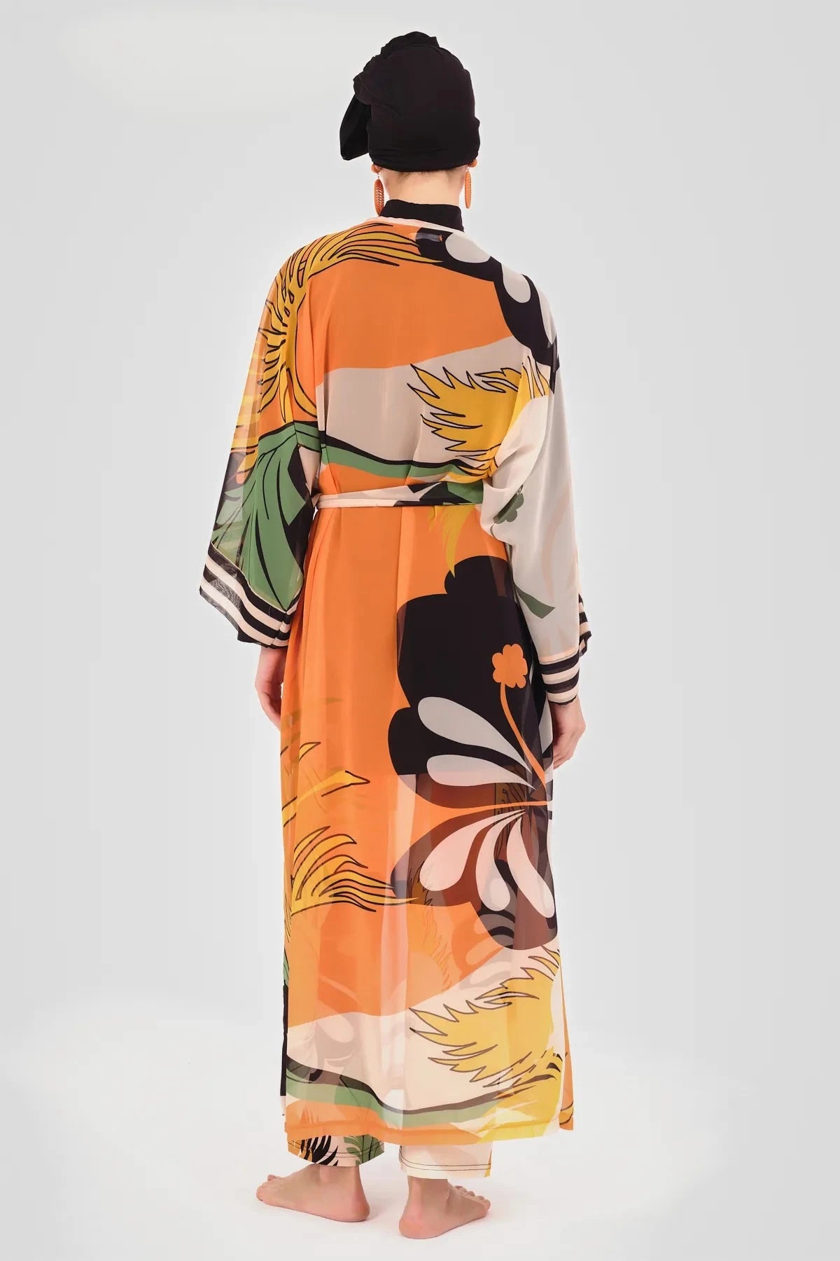 Back view of model wearing orange floral kimono with tie belt.