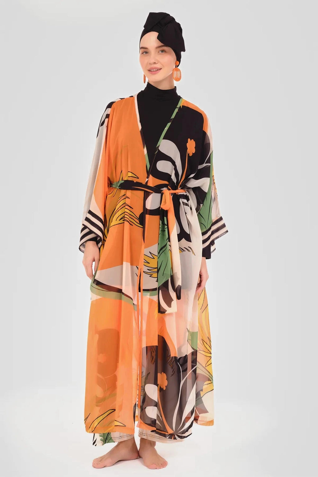Front view of model wearing orange floral kimono over black swimwear.