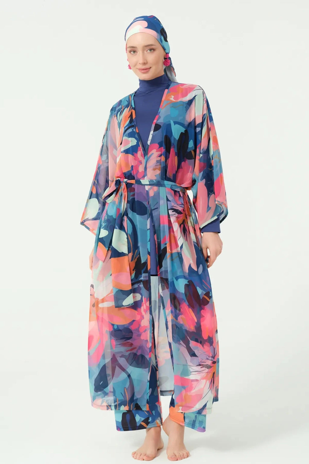 Woman wearing floral print sheer kimono with tie belt over navy burkini.