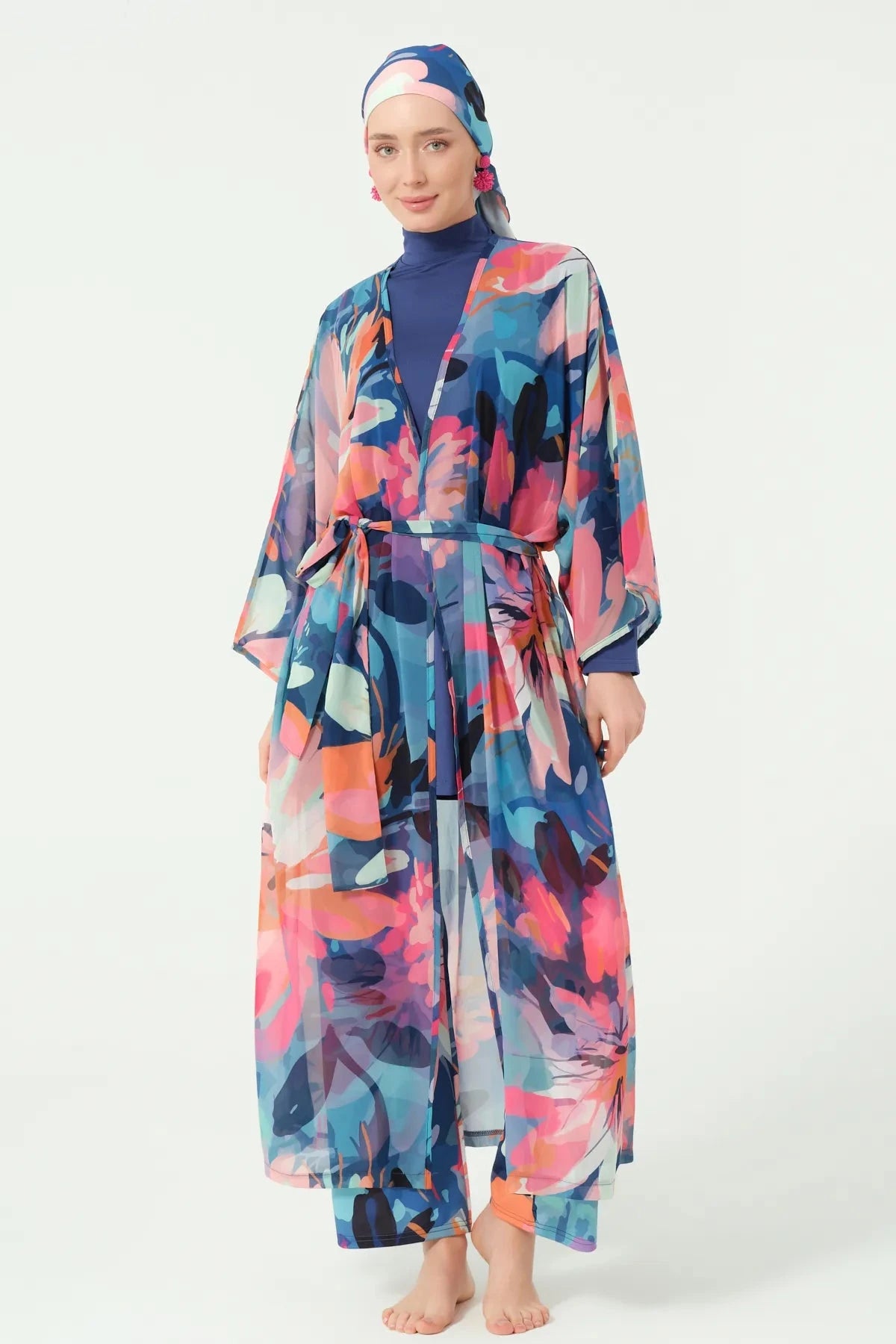 Woman wearing floral print sheer kimono with tie belt over navy burkini.