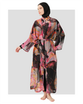 Woman in vibrant abstract print kimono cover-up with tie belt, front view.