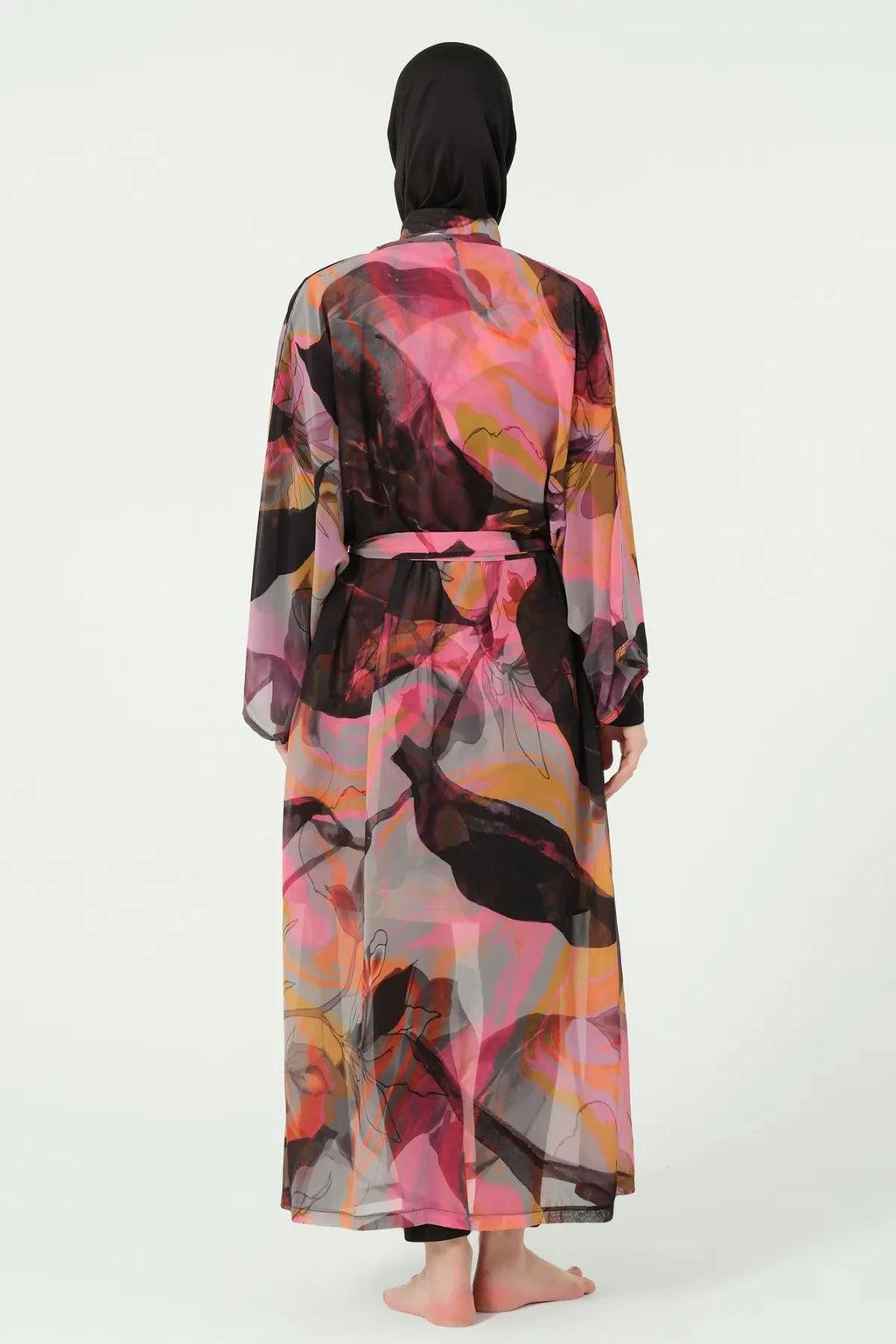 Woman in vibrant abstract print kimono cover-up with tie belt, back view.