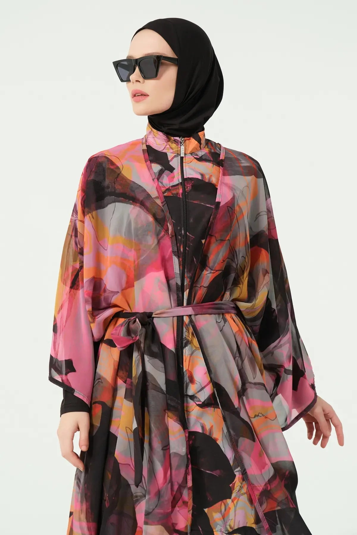 Close-up of woman in vibrant abstract print kimono cover-up and sunglasses.