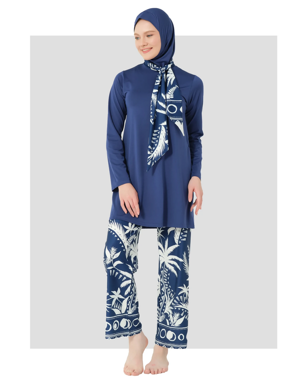 Model in navy burkini top, palm print swim pants, and scarf.