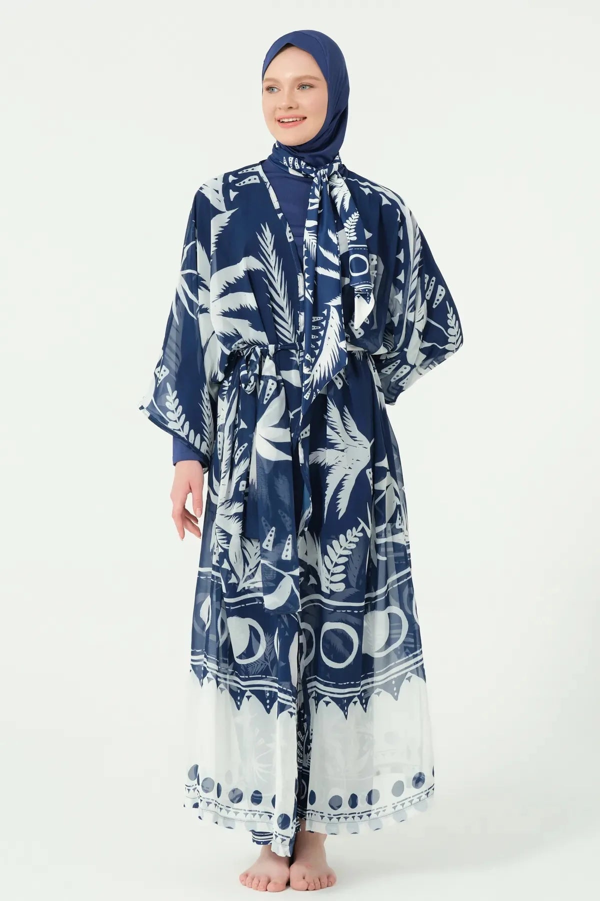 Model in navy burkini set with palm print sheer kimono tied.