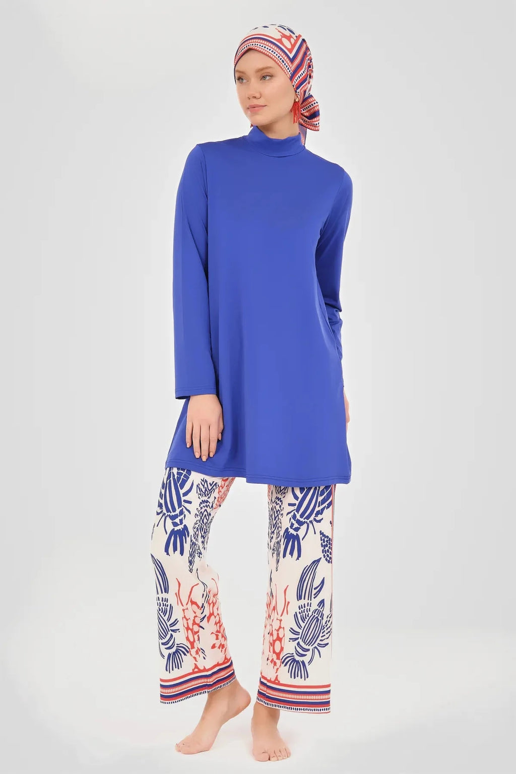 Model in blue modest swim top and printed wide-leg pants, front.