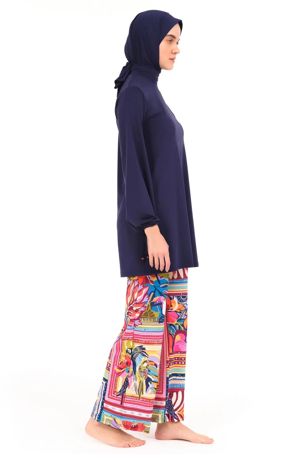 Model in navy tunic and tropical print swim pants, left side view.