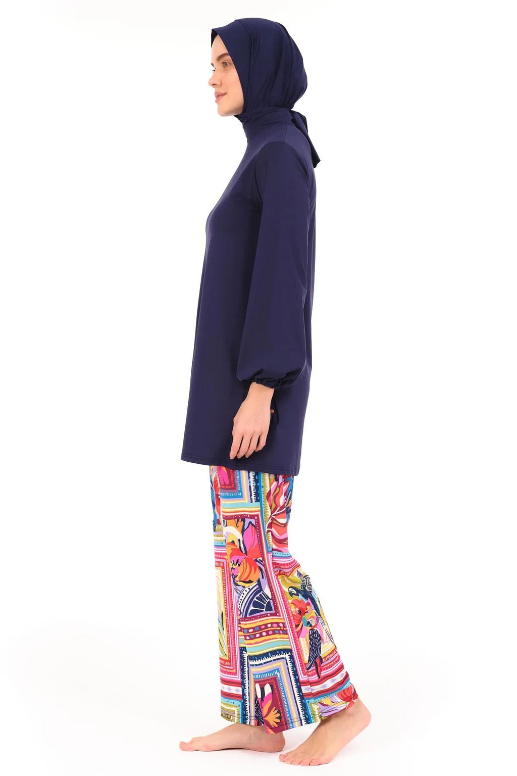 Model in navy tunic and tropical print swim pants, right side view.