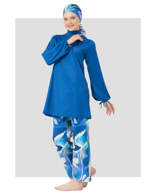 Woman in deep azure modest swimwear set, side view, patterned pants.