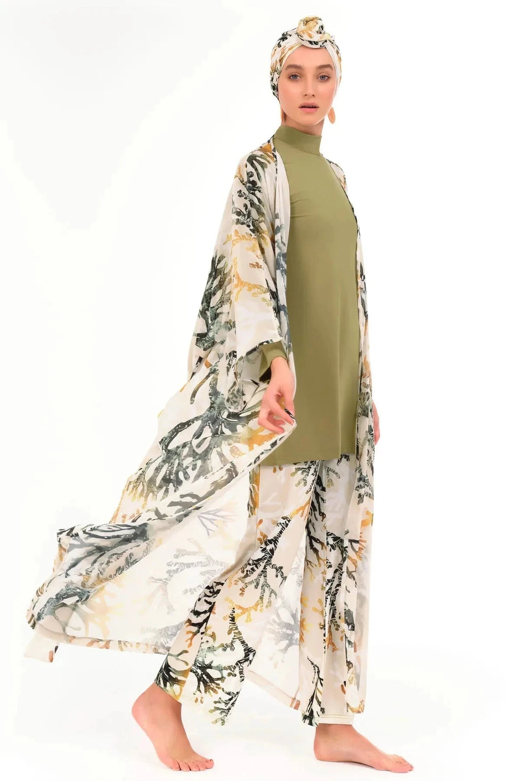 Woman walking in golden olive kimono, open, showing modest swimwear.