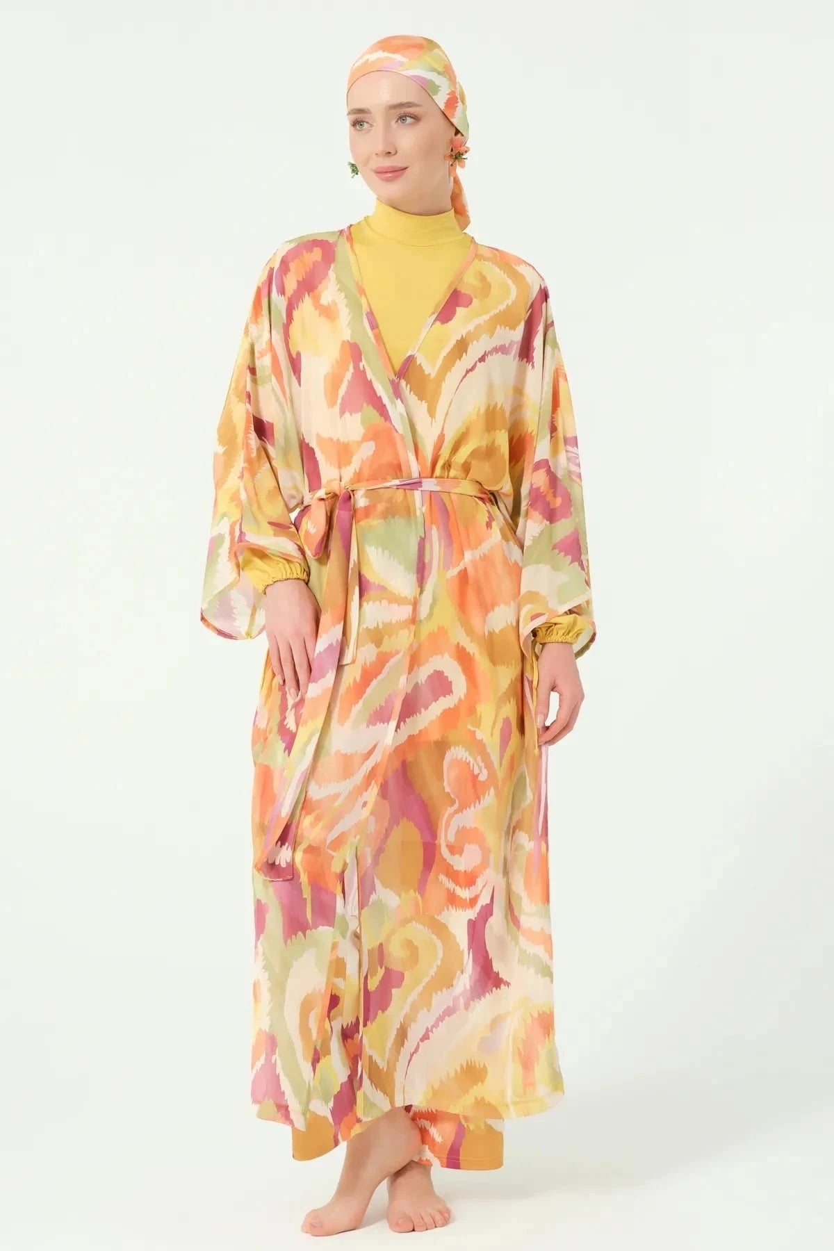 Woman in golden sunset sheer kimono with belt posing front.