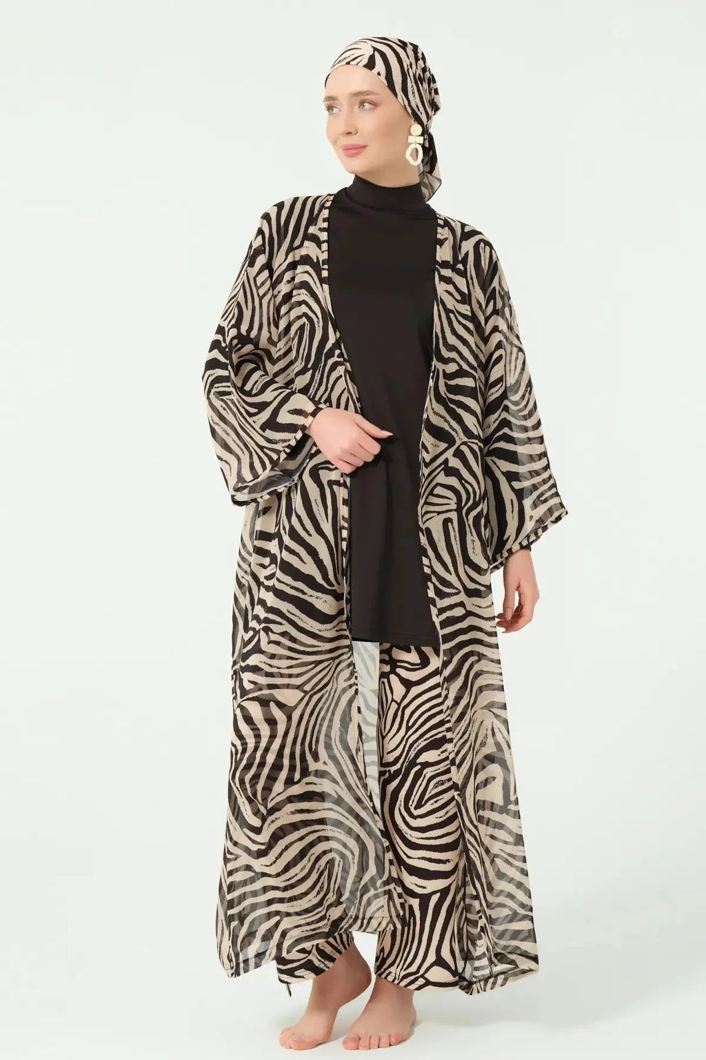 Model standing with open zebra print kimono over black full coverage swimwear.