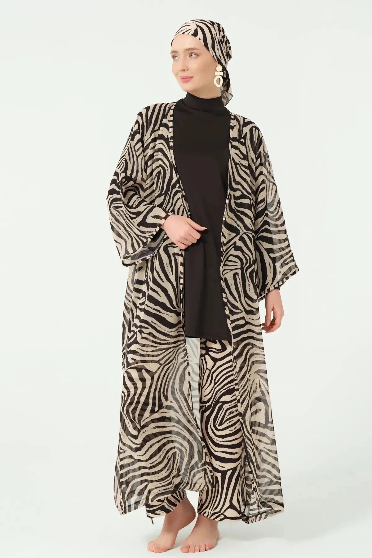 Model standing with open zebra print kimono over black full coverage swimwear.