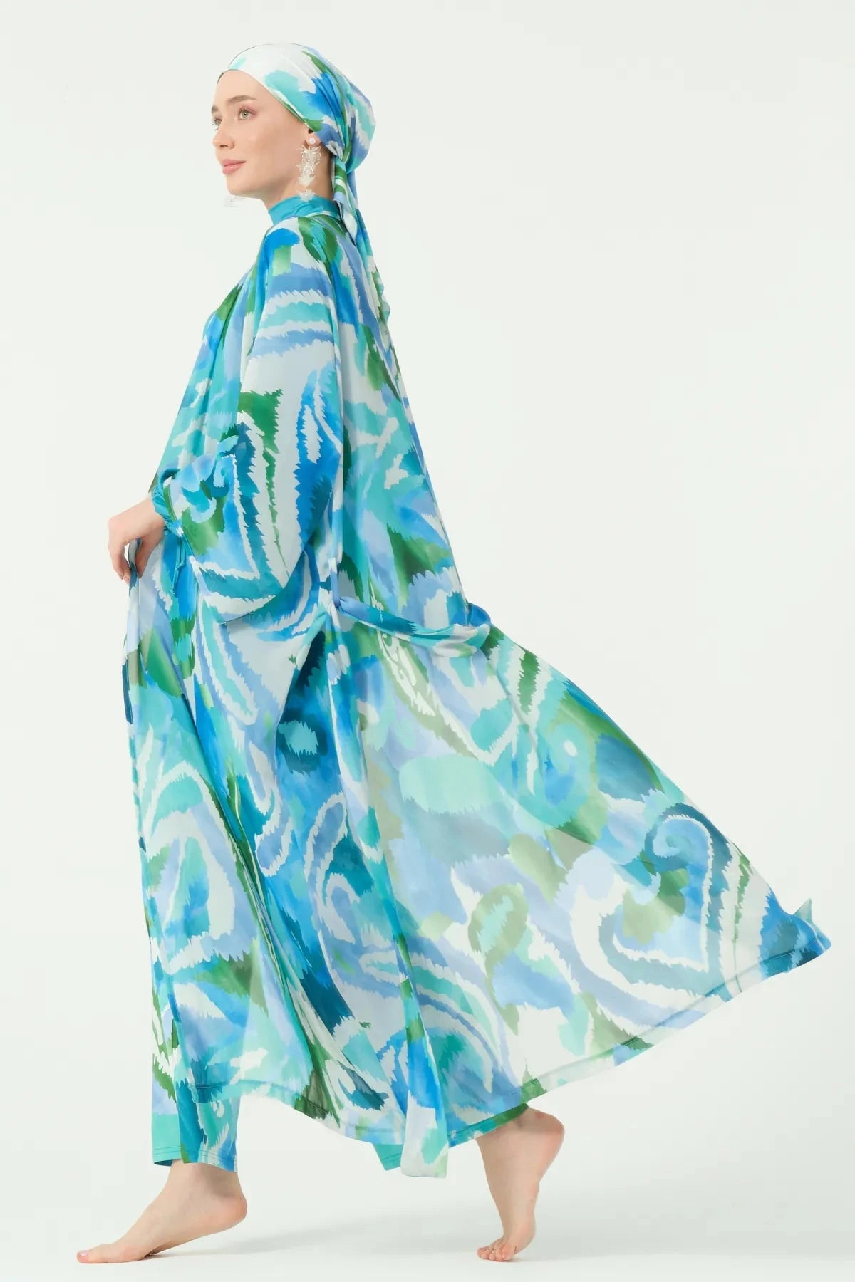 Side view of model in patterned kimono, fabric flowing elegantly.