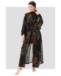 Woman in dark patterned kimono and matching head covering, front view.