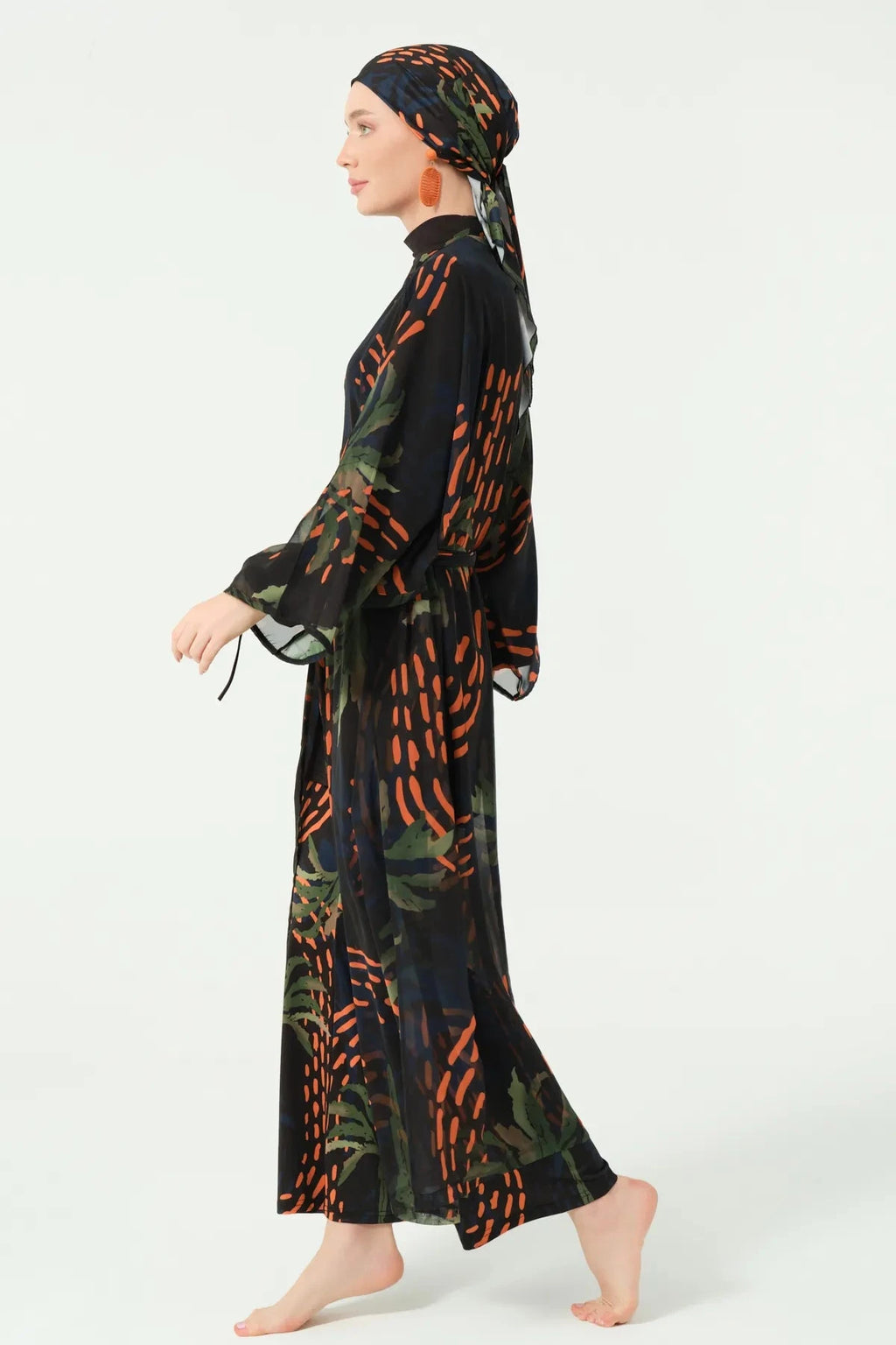 Woman in dark patterned kimono and head covering, side profile.