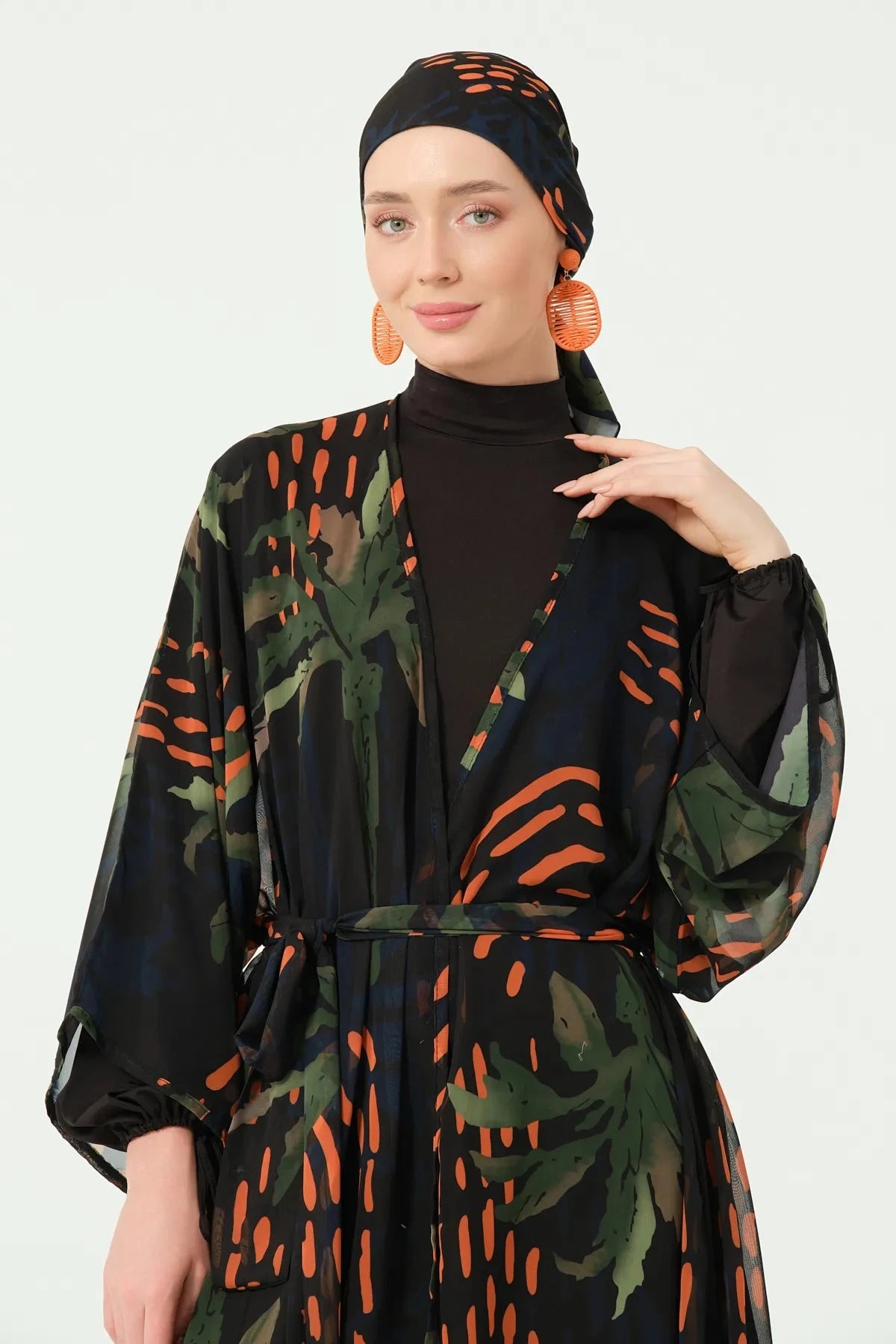Close-up of woman in patterned kimono and black turtleneck, smiling.