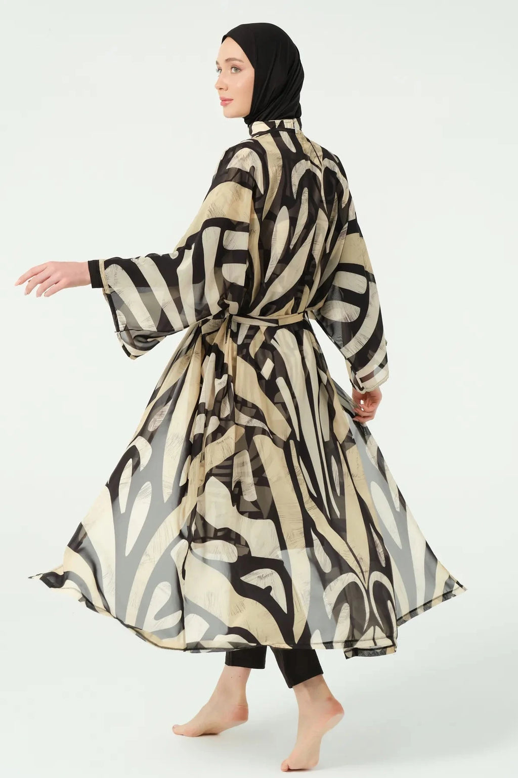 Back view of model wearing flowing black and beige abstract print kimono.