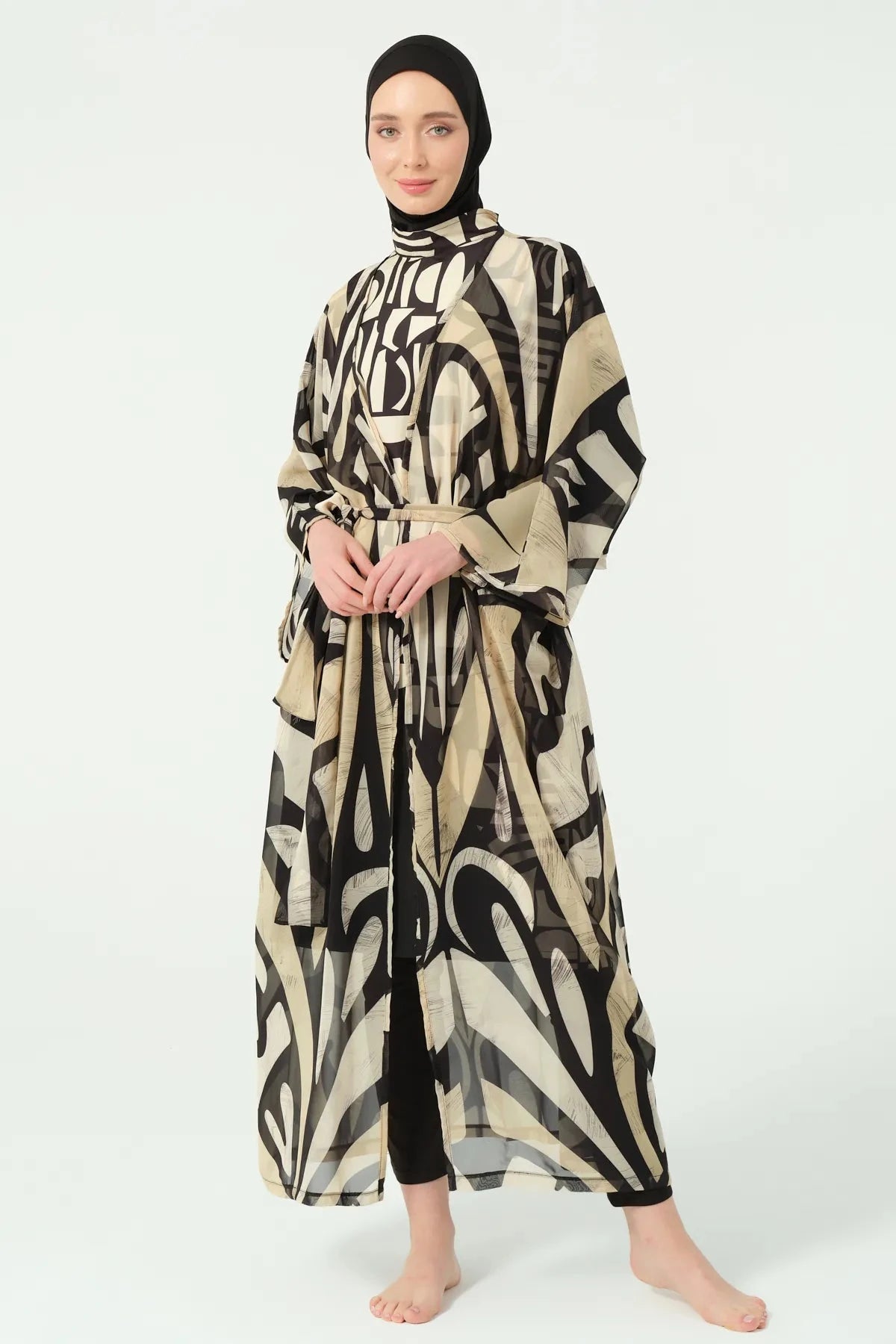 Front view of model in black and beige abstract print kimono with tie belt.