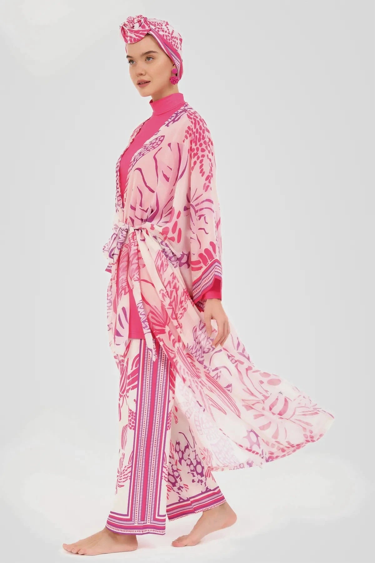 Model in tropical fuchsia burkini set with flowing sheer kimono side view.