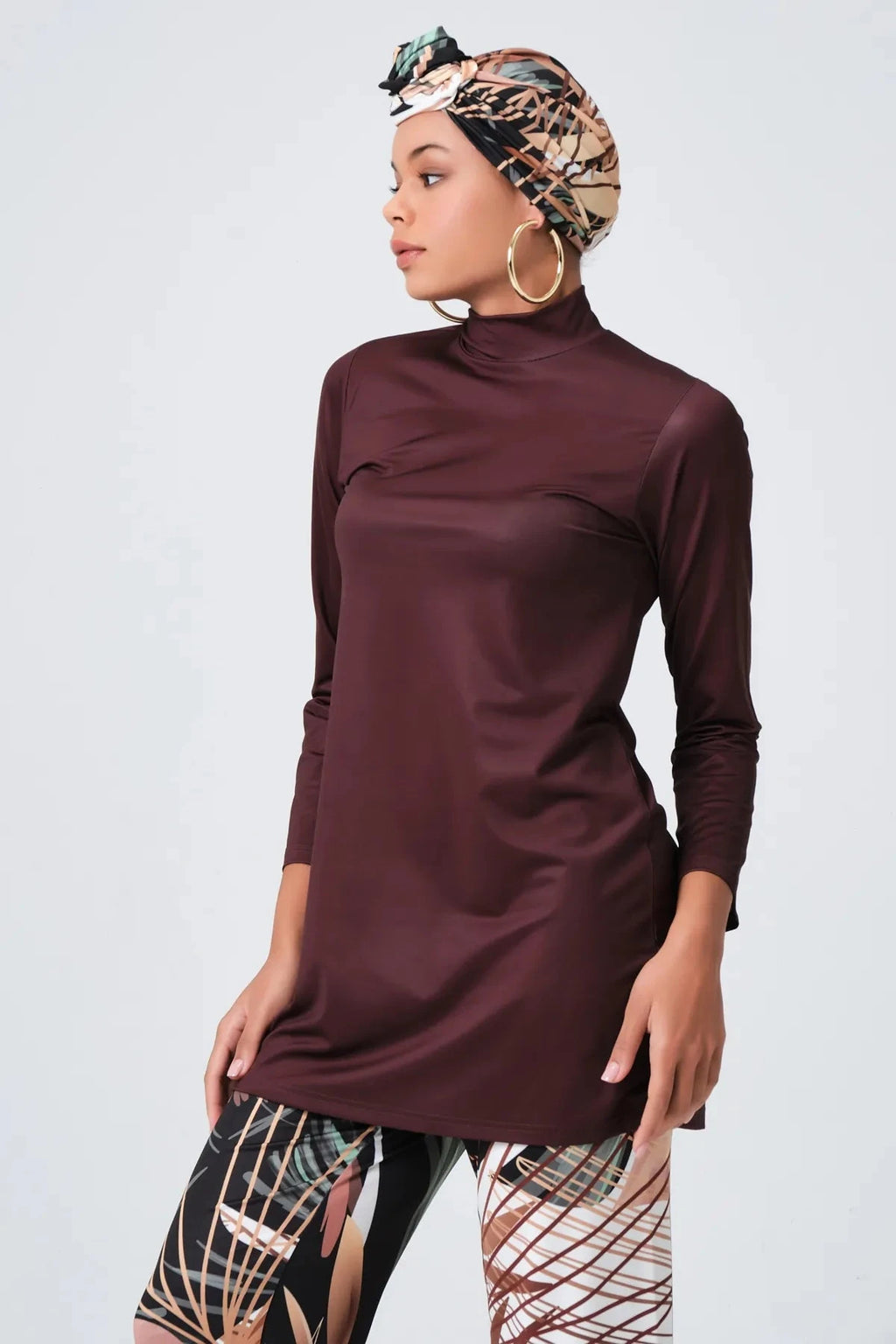 Model in rich brown modest swimwear set side profile with patterned head covering.